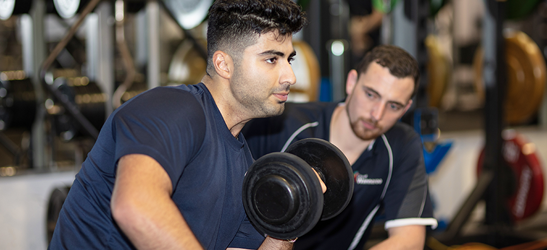 Personal trainer guiding a client doing exercises