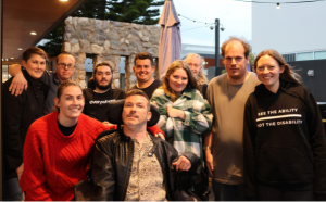 Group of adults posing together at the beergarden of a pub.