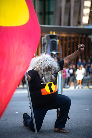Uncle Herbert Bropho kneeling at corner of St George’s Tce and William St during a protest marking three decades since the 1991 Royal Commission into Aboriginal Deaths in Custody report was tabled, 15th April 2021, Cole Baxter. 