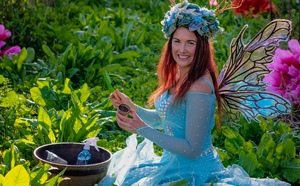 Woman dressed as fairy in garden with flowers