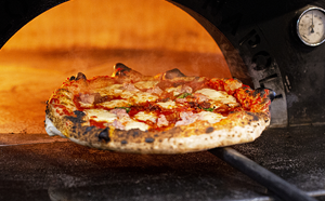 Pizza being cooked in a pizza oven