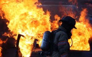 Firefighter with fire in background.